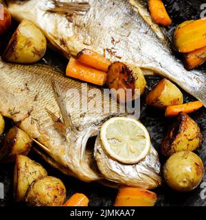 Pesce Dorado al forno con patatine e carote Foto Stock