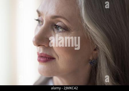 Donna pensierosa grigia con capelli che guarda via nel profondo pensiero Foto Stock