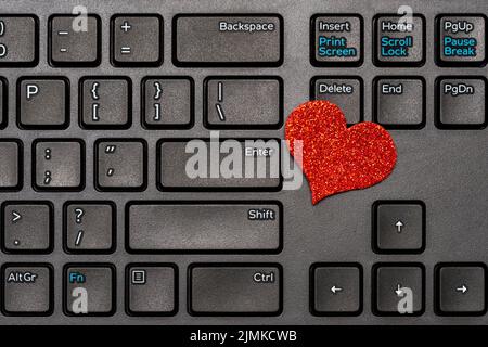 Tema del giorno di San Valentino, cuore rosso sulla tastiera del computer portatile Foto Stock