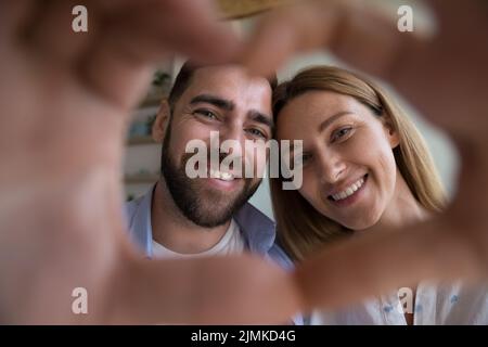 Bella coppia che mostra la forma del cuore alla fotocamera, primo piano scatto Foto Stock