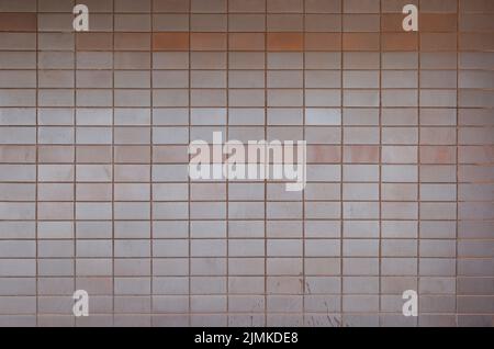 Parete in piastrelle o blocchi con alcune macchie, vista frontale. Sfondo testurizzato full frame ad alta risoluzione. Spazio di copia. Foto Stock