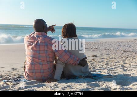 Vista posteriore della coppia senior afro-americana che trascorre il tempo libero insieme in spiaggia Foto Stock