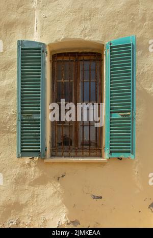 Vecchia finestra con persiane in legno e griglia arrugginita. Foto Stock