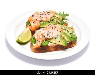 Avocado appena fatto, salmone e crema di formaggio toasts isolato su sfondo bianco Foto Stock