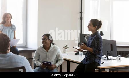 I colleghi indiani e diversi comunicano nello spazio di coworking Foto Stock