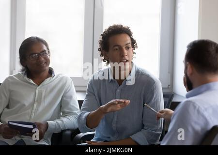 Diversi dipendenti partecipano a riunioni di gruppo riunite in ufficio Foto Stock