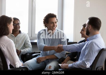 Gli uomini d'affari terminano la riunione d'affari in ufficio con una mano stretta Foto Stock