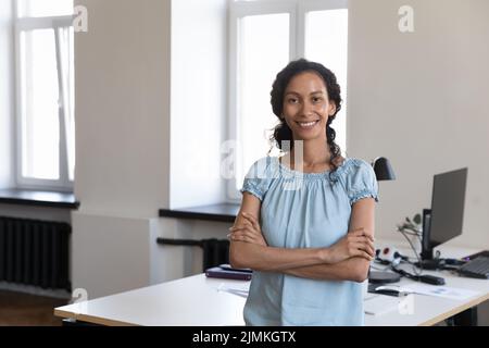 Il personale africano femminile e fiducioso si pone sul posto di lavoro Foto Stock