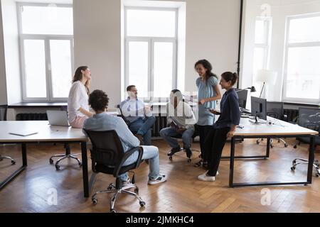 Sei dipendenti di uffici multietnici e amichevoli parlano durante le riunioni di gruppo Foto Stock