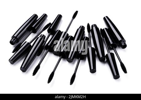 Spazzole e contenitori in mascara nero su sfondo bianco Foto Stock