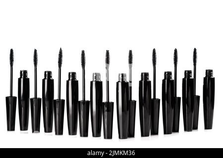 Spazzole e contenitori in mascara nero su sfondo bianco Foto Stock