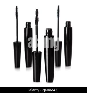 Spazzole e contenitori in mascara nero su sfondo bianco Foto Stock
