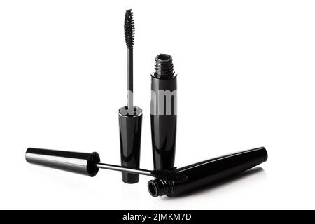 Spazzole e contenitori in mascara nero su sfondo bianco Foto Stock