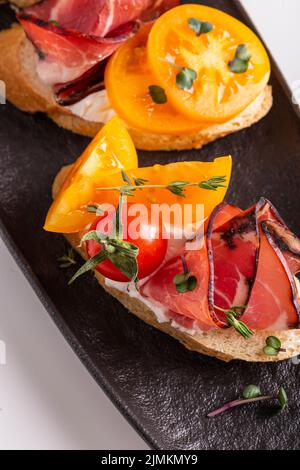 Bruschetta con pomodori e prosciutto per cena Foto Stock