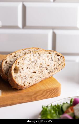 Pane appena sfornato tagliato su un asse Foto Stock