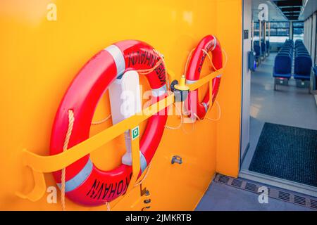 Due boe di vita rosse rotonde appendono sul ponte di una nave Copenhagen Harbour Bus. Danimarca Foto Stock