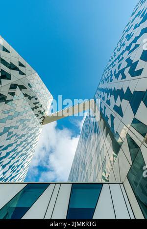 Vista dal basso di un moderno edificio in vetro bianco AC Hotel Bella Sky nella zona della città Ã˜restad. Copenaghen, Danimarca Foto Stock