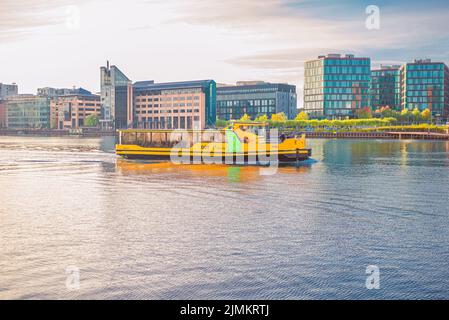 Il porto giallo di Copenhagen Water Busesthe naviga lungo il porto del canale della città vicino agli edifici residenziali di Copenhagen, Denm Foto Stock