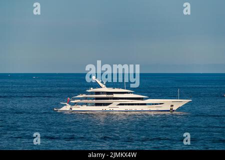 L'enorme mega yacht è ormeggiato in mare al largo della costa della costa azzurra nelle giornate di sole, il corrimano cromato, sole reflectio Foto Stock