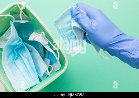 Persona che indossa guanti protettivi con maschera monouso Foto Stock