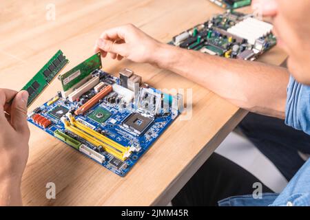 Ingegnere che mette la scheda madre del modulo di memoria RAM Foto Stock