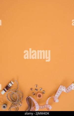 Pulsante della corda di iuta della spola con nastro di misurazione sfondo arancione Foto Stock