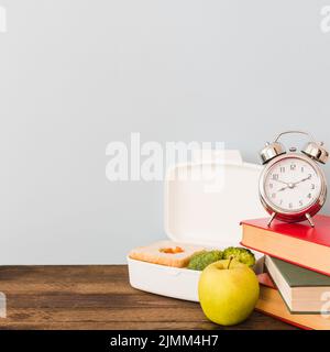 Sveglia libri vicino a cibo sano Foto Stock