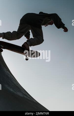 Un adolescente che si diverte con il parco skateboard all'aperto Foto Stock