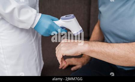 Medico che assume la temperatura dei pazienti Foto Stock