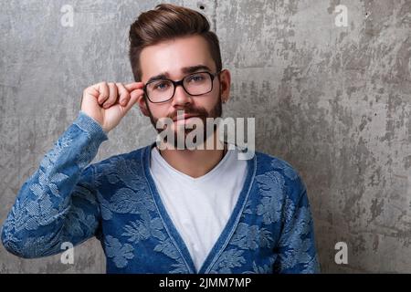 Bel giovane uomo portatore che indossa gli occhiali Foto Stock