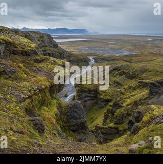 Splendida vista autunnale dal Canyon di Mulagljufur al ghiacciaio di Fjallsarlon con la laguna di ghiaccio di Breidarlon, Islanda e Oceano Atlantico in lontano. Si trova all'estremità sud di Foto Stock