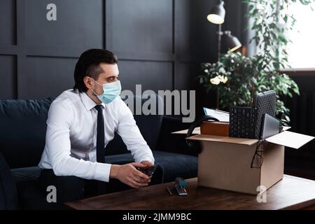 Giovane uomo che viene licenziato dal suo lavoro a causa di pandemia virale Foto Stock