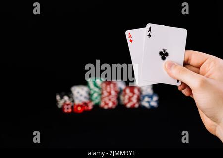Mano umana che tiene due assi carte da gioco Foto Stock