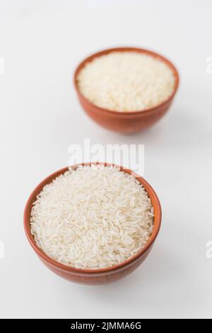 Primo piano ciotole di riso al gelsomino crudo carta da parati bianca Foto Stock