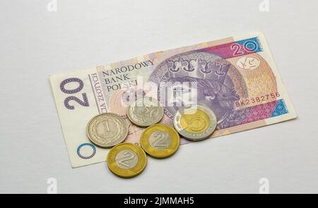 Cinquanta banconote e monete polacche si rialzano contro il bianco Foto Stock