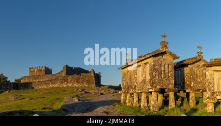 Il castello di Lindoso e i granai storici in pietra nel villaggio di Lindoso in Portogallo in calda luce serale Foto Stock