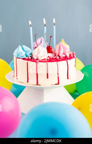 Torta con candele palloncini Foto Stock