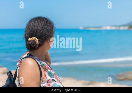 Donna di origine marocchina che guarda un mare fuori fuoco. Concetto di nuova generazione Foto Stock