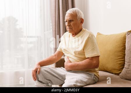 L'uomo anziano soffre di problemi di digestione Foto Stock