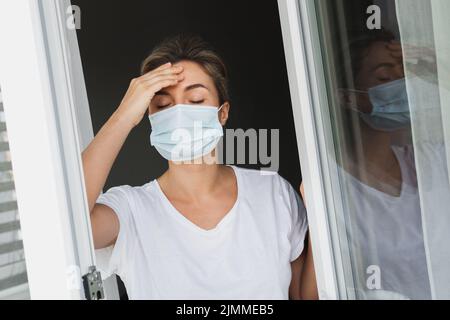 Donna stanca con maschera di prevenzione che va fuori Foto Stock