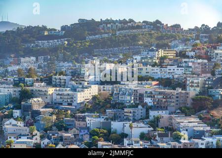 Edifici residenziali su un pendio a San Francisco, California. Quartiere su una montagna con edifici di appartamenti contro il cielo limpido al backgr Foto Stock