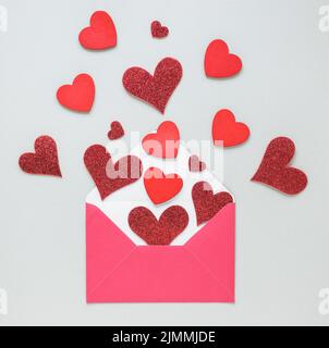 Cuori di carta sparsi dalla busta Foto Stock