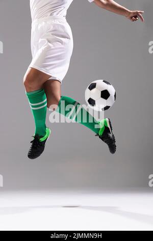 Donna adulta fare trucchi con palla di calcio Foto Stock