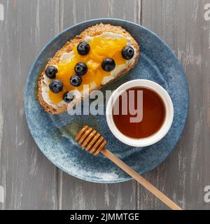 Piatto di pane con formaggio cremoso piatto di frutta con miele Foto Stock