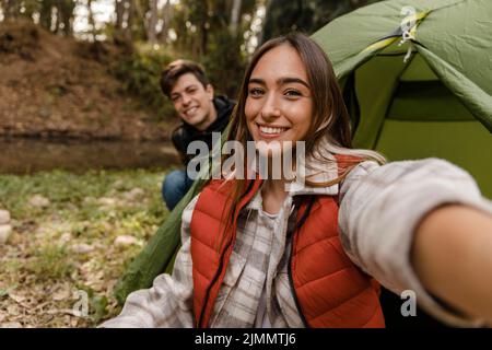 Felice coppia foresta prendere selfie Foto Stock