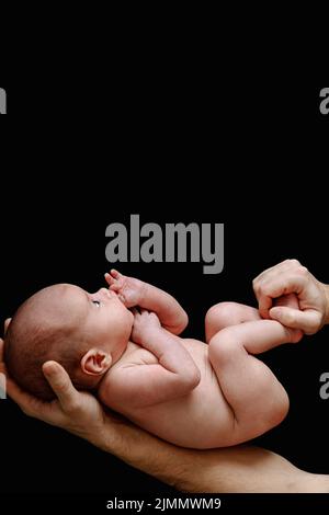 Cute neonato bambino giacente nelle mani del padre Foto Stock