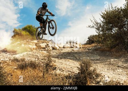 Motociclista professionista che salta durante la discesa in bicicletta Foto Stock