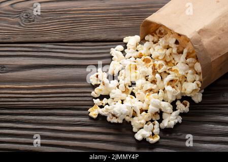 Spuntino a base di mais in sacchetto di carta sul primo piano del tavolo di legno Foto Stock