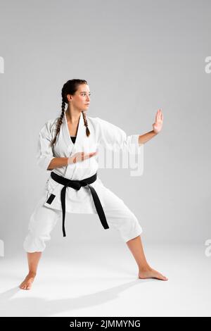 Full length shot donna con cintura nera kimono pratica karate Foto Stock