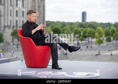 Berlino, Germania. 07th ago 2022. Martin Schirdewan, Co-Vorsitzender der Partei Die Linke, sitzt vor dem ARD-Sommerintervista im «Bericht aus Berlin» auf einem roten Sessel. Credit: Christophe Gateau/dpa/Alamy Live News Foto Stock